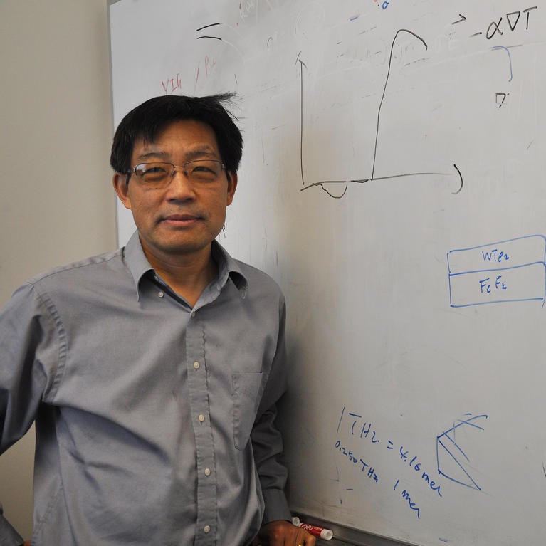 Jing Shi standing in front of white board